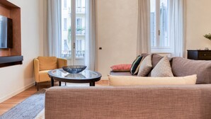 Ein Wohnzimmer mit Sofa, Sessel und rundem Couchtisch.