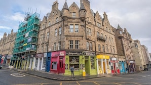 A historic building with a corner entrance, featuring a café and a restaurant named 'Holyrood Cafe' and 'Holyrood Restaurant'. - Charming 2-Bed flat Steps from the Royal Mile - Pass the Keys (Edinburgh)