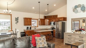 A modern kitchen with wooden cabinets, stainless steel appliances, and a large island.