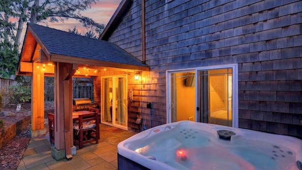 A wooden house with a hot tub, a barbecue area, and a covered patio. - Tides & Timber by Avantstay Lakeside Retreat + Hot Tub + Kayaks + Paddleboard + Bikes Near Beach (Rockaway Beach)