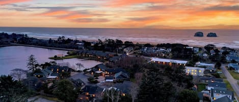 A coastal residential area with houses, a lake, and a sunset view.