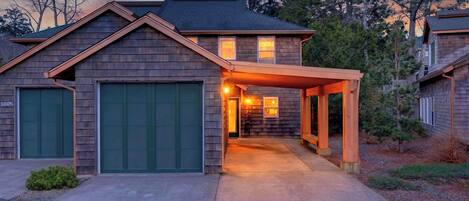 Ein zweigeschossiges Haus mit überdachter Veranda und Garage.