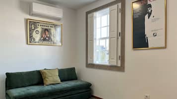 Habitación triple Deluxe, vista a la ciudad | Área de sala de estar