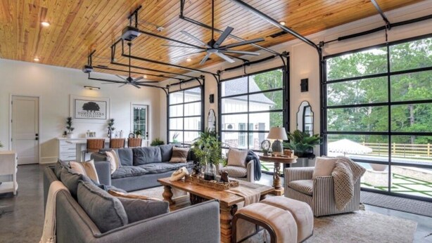 A spacious living room with a large gray sectional sofa, a wooden coffee table, and striped armchairs. - Three Oaks Estate & Luxury Masters Tournament Retreat & Resort Pool (Harlem)