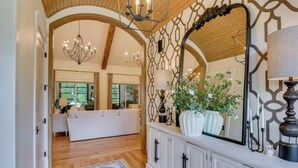 A spacious hallway with a wooden ceiling, a large mirror, and a white console with cabinets. - Three Oaks Estate & Luxury Masters Tournament Retreat & Resort Pool (Harlem)