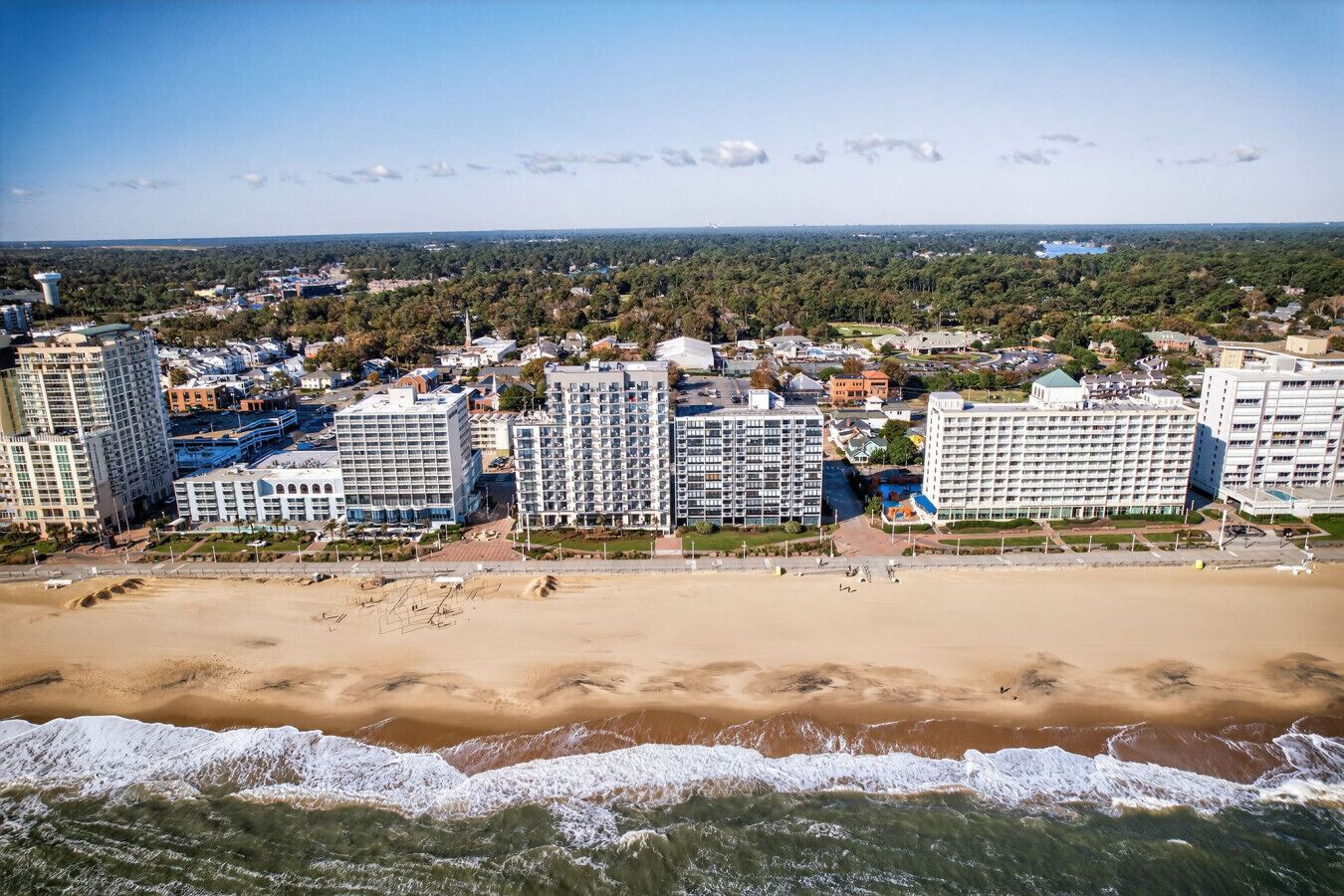 Ein Küstenhotel mit mehreren Hochhäusern, einem Sandstrand und Blick auf den Ozean.