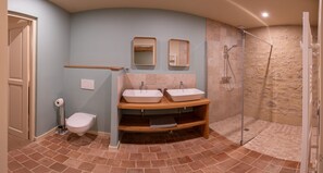 Een douche, handdoeken, zeep, toiletpapier