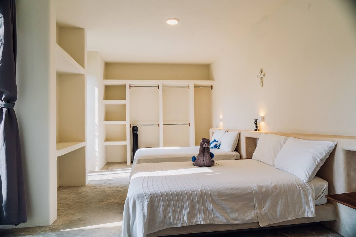 A hotel room with a bed, a nightstand, a wardrobe, and a bedside table.