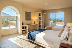 A bedroom with a bed, bedside tables, a desk, and a large window offering a view of the outdoors. - Private Ocean View Retreat with Pool | Luxury HOM (Troncones)