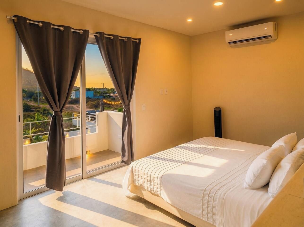 Une chambre à coucher avec un lit, des rideaux, un appareil de climatisation et une vue à travers les rideaux.