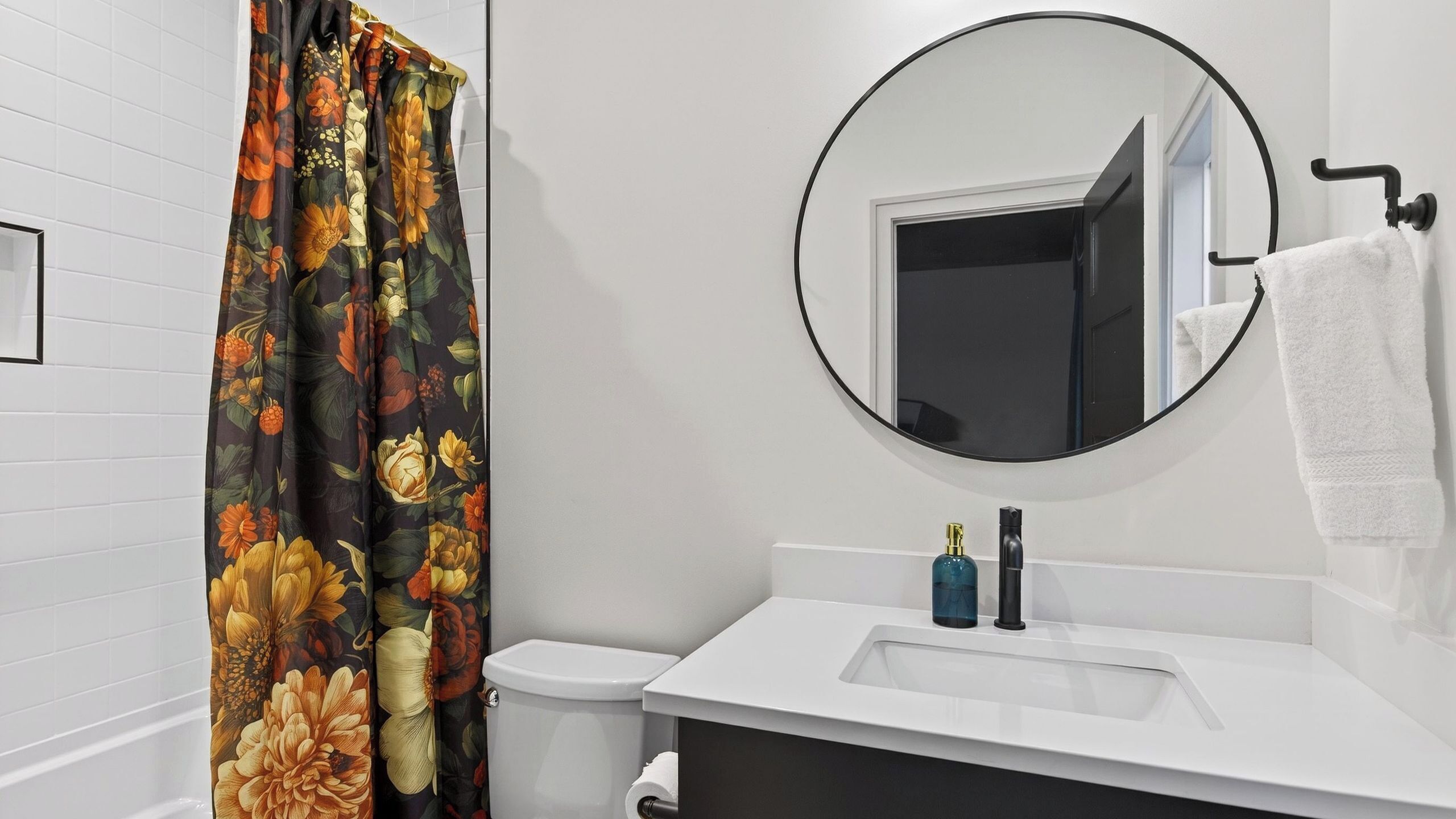 A bathroom with a toilet, sink, and mirror.