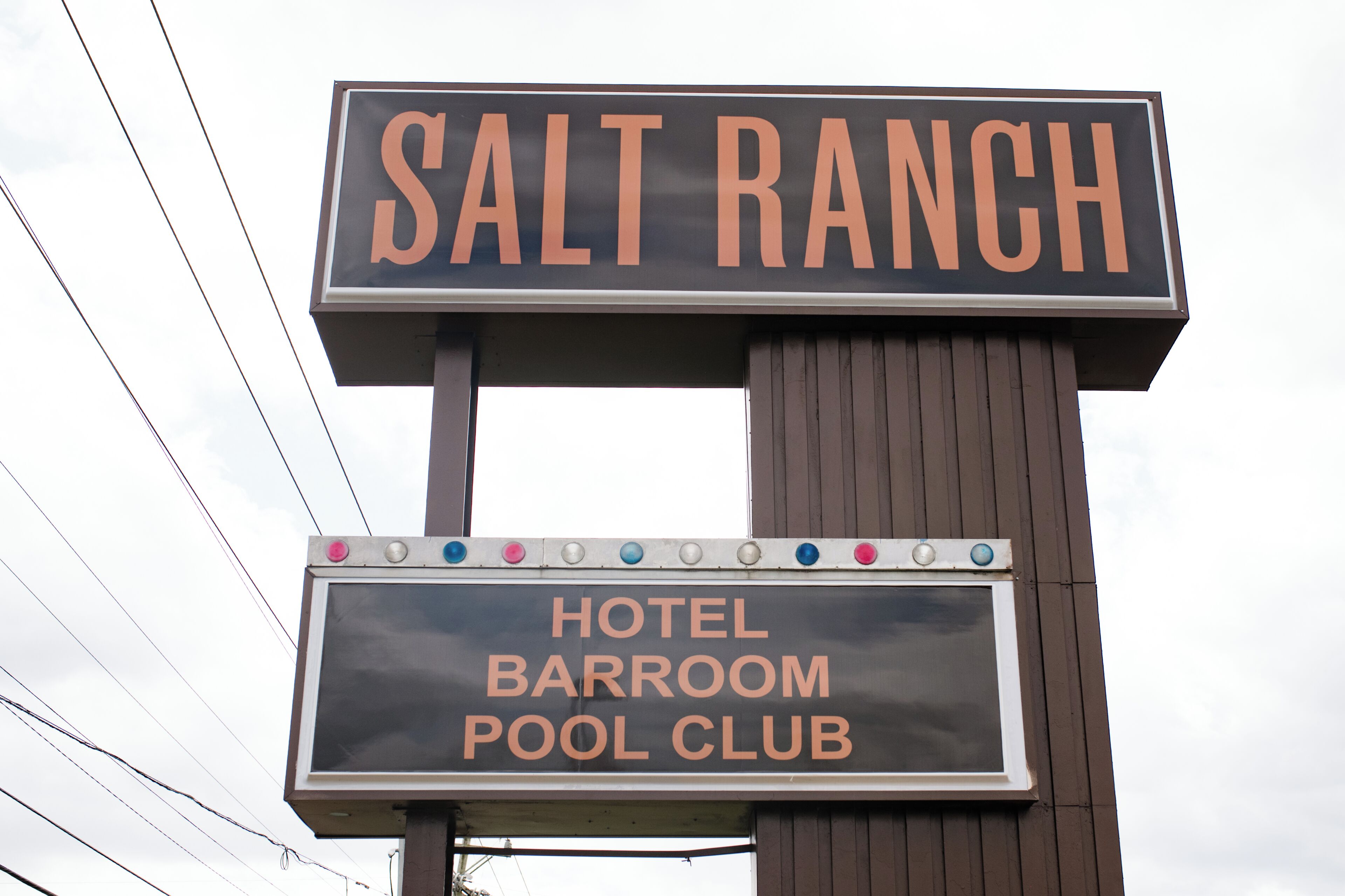 Letrero de un club de piscina y bar del hotel con el nombre 'SALT RANCH' en destaque.