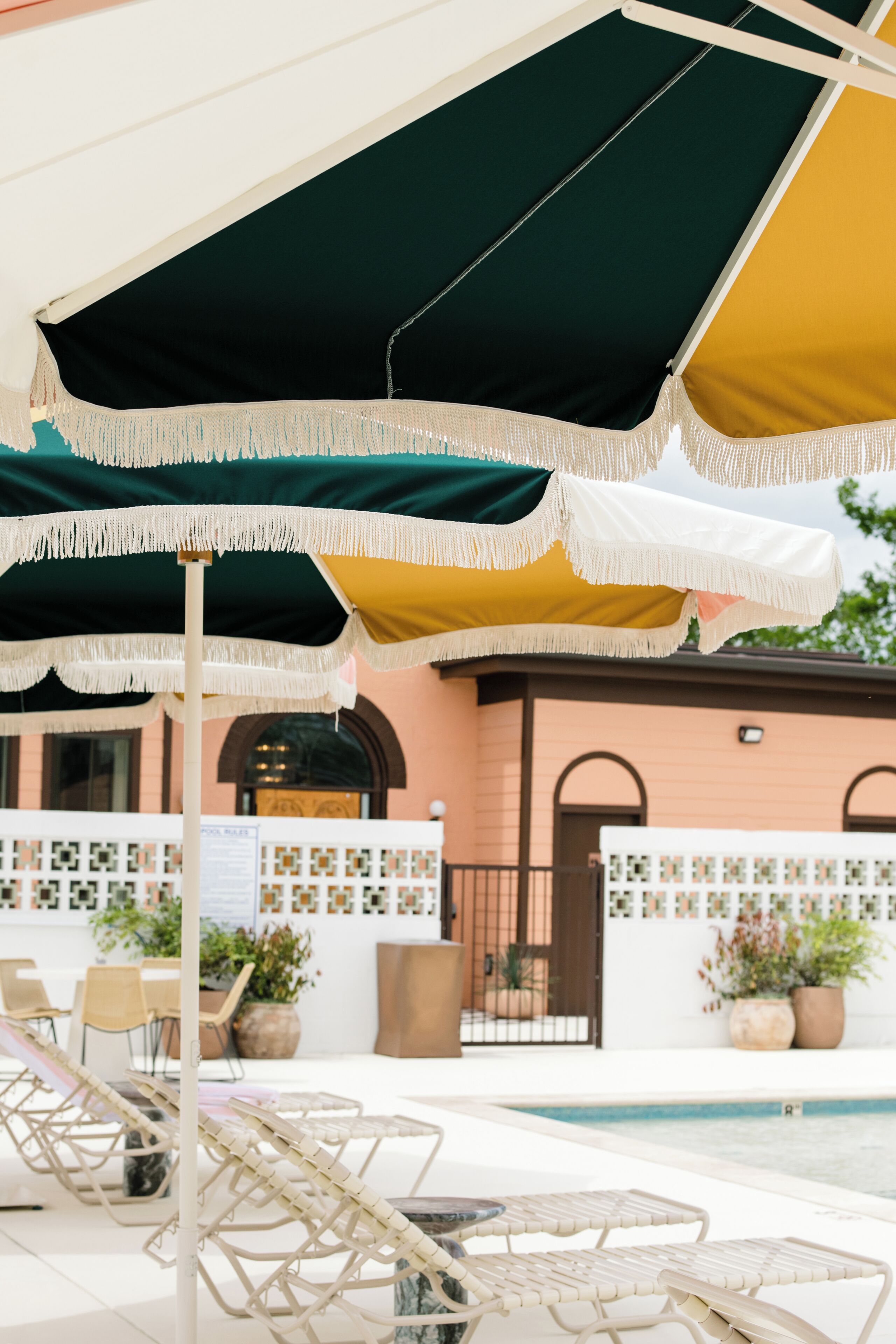 A poolside area with lounge chairs and a large umbrella.