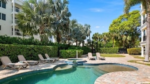 A swimming pool with lounge chairs, palm trees, and a brick pathway. - Luxury 4-bedroom Penthouse in Siesta Key- Private rooftop terrace (Siesta Key)