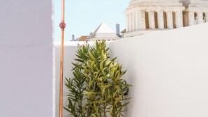 A rooftop with a tall pole, potted plants, and a white building with a dome in the background. - Luxury Penthouse • Rooftop • Sea views • Private Parking (Estepona)