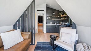 En modern loftlägenhet med en trappa som leder upp till ett kök och ett vardagsrum.