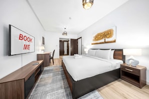 A modern hotel room with a large bed, a desk, a chair, a TV, and a painting on the wall. - Stayshort - 2 Bed in Dubai Marina That Sleeps 5 (Dubai)