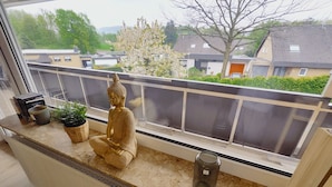 A room with a window overlooking a residential area, a statue on the windowsill, and a radiator below. - Henno's Apartment (Bielefeld)