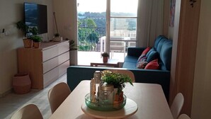 A dining area with a table, chairs, a TV, and a view of the outdoors. - Your best vacations in Mijas (Mijas)