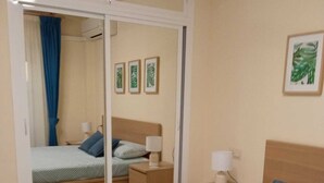 A bedroom with a bed, a nightstand, a dresser, and a sliding door closet. - Your best vacations in Mijas (Mijas)
