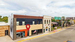 A multi-story building with a modern facade, a visible American flag, and a street sign indicating nearby destinations.