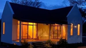 A small, single-story house with a sloped roof, large windows, and a visible porch area. - 4U Resort & Camp (Yaring)