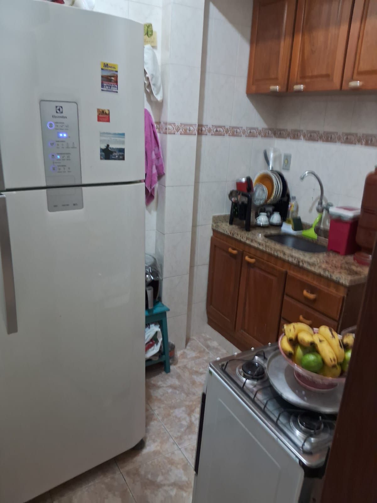 A compact kitchen with a refrigerator, stove, and sink.