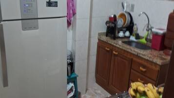 A compact kitchen with a refrigerator, stove, and sink.