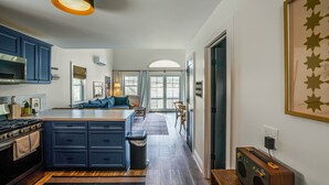 Une cuisine moderne dotée d’un îlot central, d’appareils électroménagers intégrés et d’une grande fenêtre.