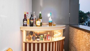 Angolo bar con diverse bottiglie di liquore e un bicchierino da shot sul bancone.