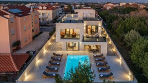 Um hotel moderno com piscina no terraço, várias opções de restaurantes e uma vista panorâmica das montanhas.