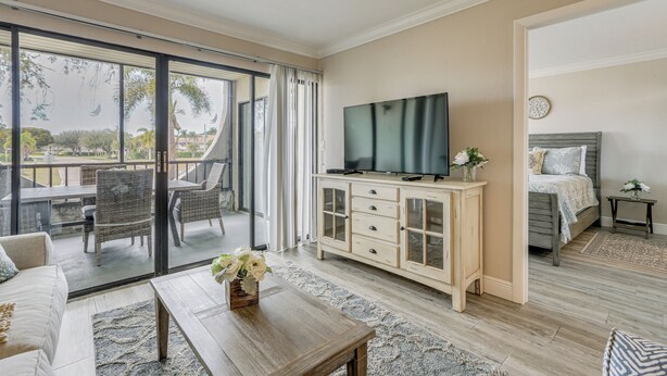 A spacious room with a balcony, a television, a bed, and a dining area. - 2 Mi to Tigertail Beach! Resort-Style Gem w/ Pool (Marco Island)
