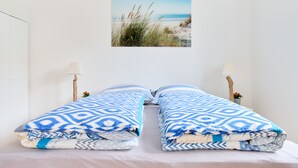 Un lit avec une couverture à motifs et deux lampes de chevet.