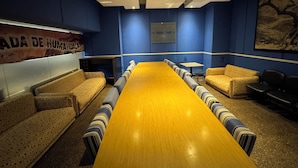 A conference room with a long table, patterned sofas, and a blue accent wall. - Hotel Quebrada de Humahuaca (San Salvador de Jujuy)