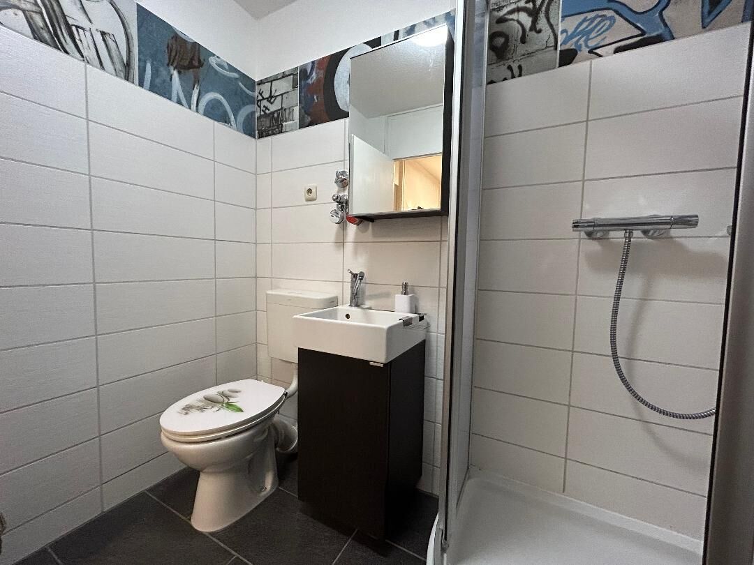 A bathroom with a toilet, sink, and shower.