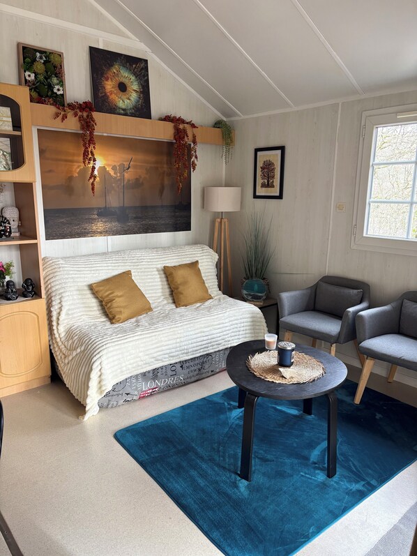 A bedroom with a large bed, a bedside table, a chair, a lamp, and a window.