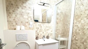 Ein modernes Badezimmer mit Toilette, Waschbecken und Dusche.