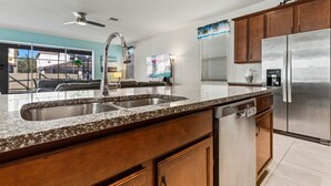 Eine moderne Küche mit Granit Arbeitsplatten, Edelstahlgeräten und Holzausstattung.