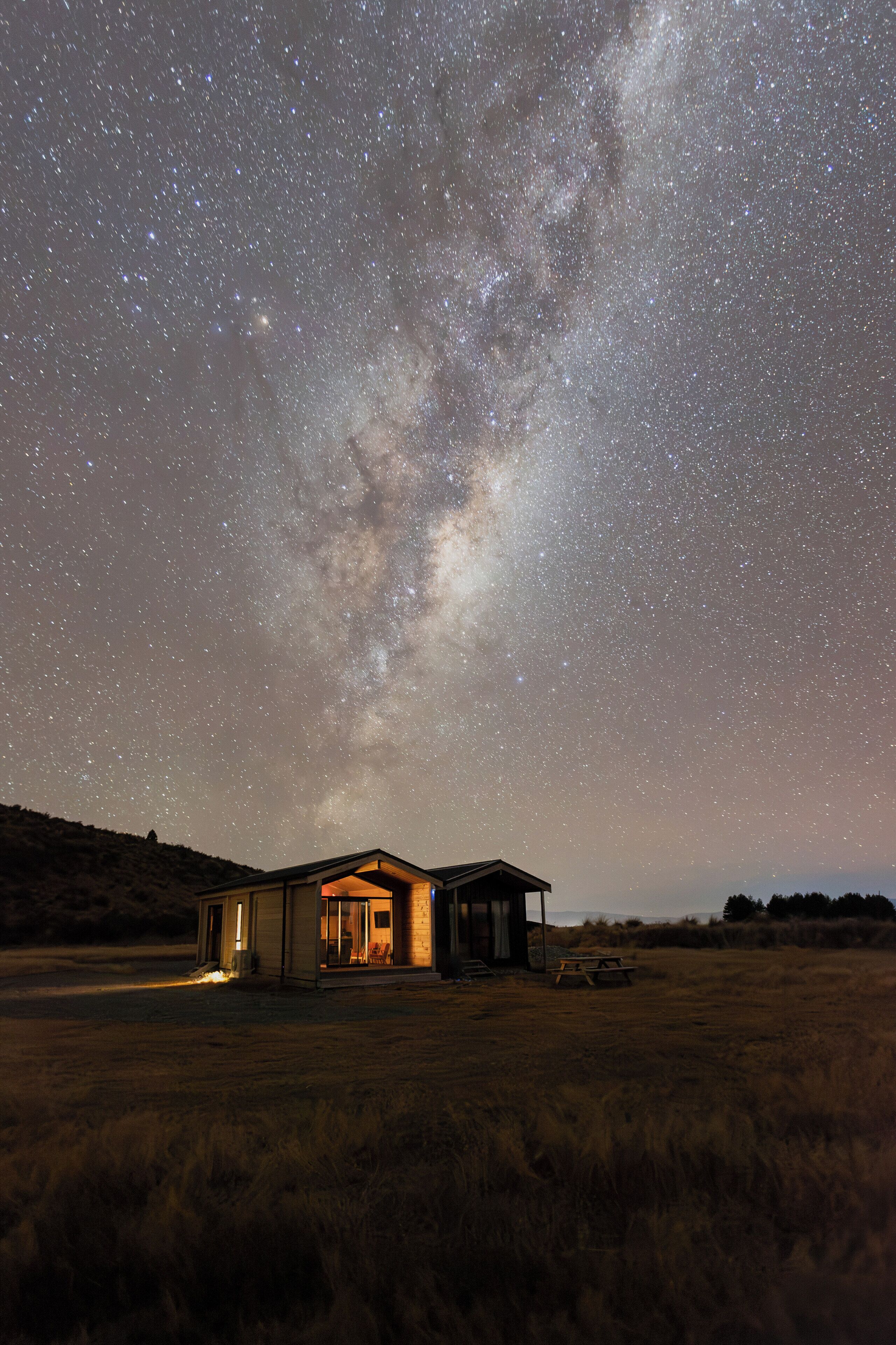 A house with a porch under a starry night sky.