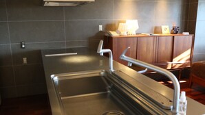 Una cocina moderna con un lavamanos de acero inoxidable, armarios de madera y un horno empotrado.