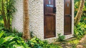A stone building with two wooden doors labeled "WASHROOM".