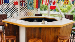 A bar area with a wooden counter and stools.