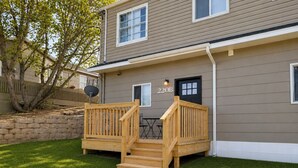 A two-story residential building with a wooden deck, a mailbox, and a number '220B' on the front. - Sun-Filled Home | Walk to Downtown & Dining (Rapid City)
