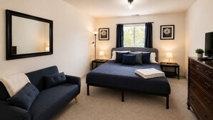 A bedroom with a bed, a sofa, a dresser, and a large mirror. - Sun-Filled Home | Walk to Downtown & Dining (Rapid City)