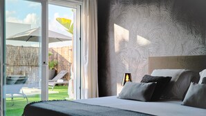 A bedroom with a large bed, a view of the outdoor area, and a patterned wall. - Villa Julieta – Ibiza Town (2 min) (Nuestra Señora De Jesus)