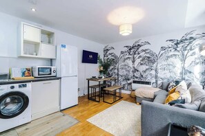 A compact living space with a kitchen, a dining area, and a seating area. - Manchester City Center | Free Parking + Wi‑Fi (Manchester)