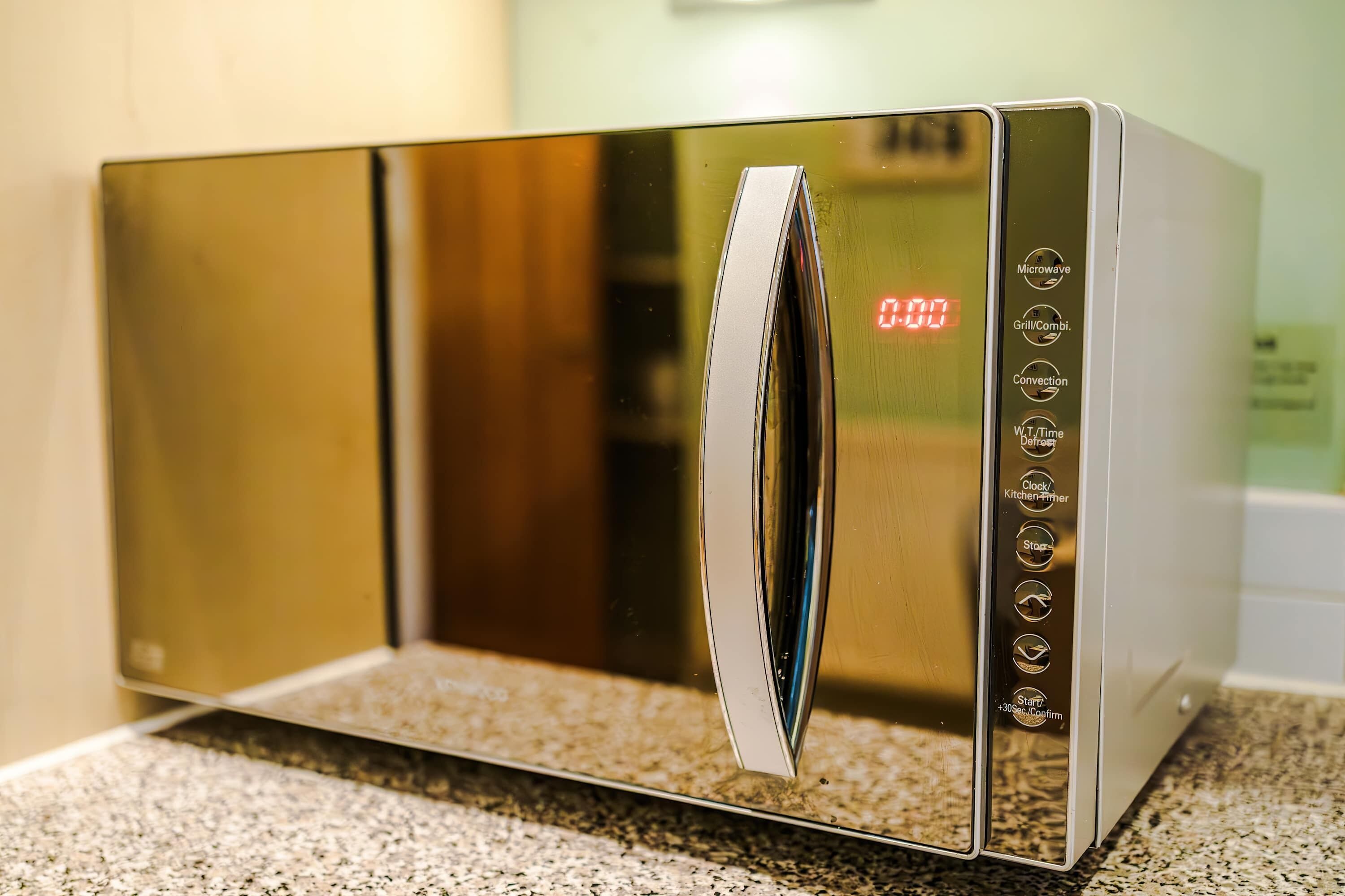 Een moderne magnetron met een digitaal display en verschillende kookfuncties.