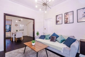 Una sala de estar moderna con un sofá, una mesita de centro y una obra de arte en la pared.