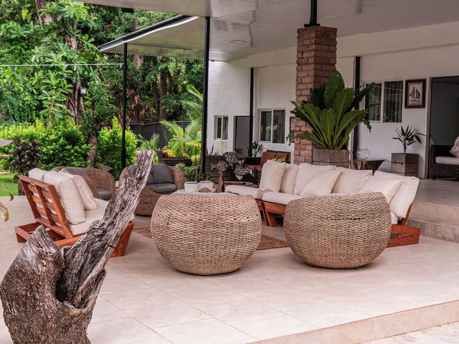 A modern living area with a sofa, two woven poufs, and a coffee table.