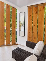 Una habitación con sofá, espejo y puertas correderas de madera.